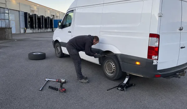 Kaubikute rehviabi, tehnik vahetab laadimisalal valge kaubiku tagaratast, maas tungraud, löökmutrivõti ja vana ratas, rehviabi lõpus mõõdetakse ka ülejäänud rehvide mustrisügavus ja tulemus öeldakse kliendile.