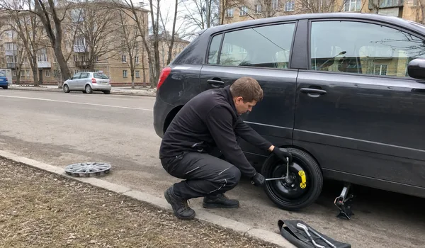 Varuratta paigaldus tänaval, tehnik kinnitab tungrauaga tõstetud tumeda luukpära varuratast, aastal 2025 paigaldati kohapeal 581 varuratast.